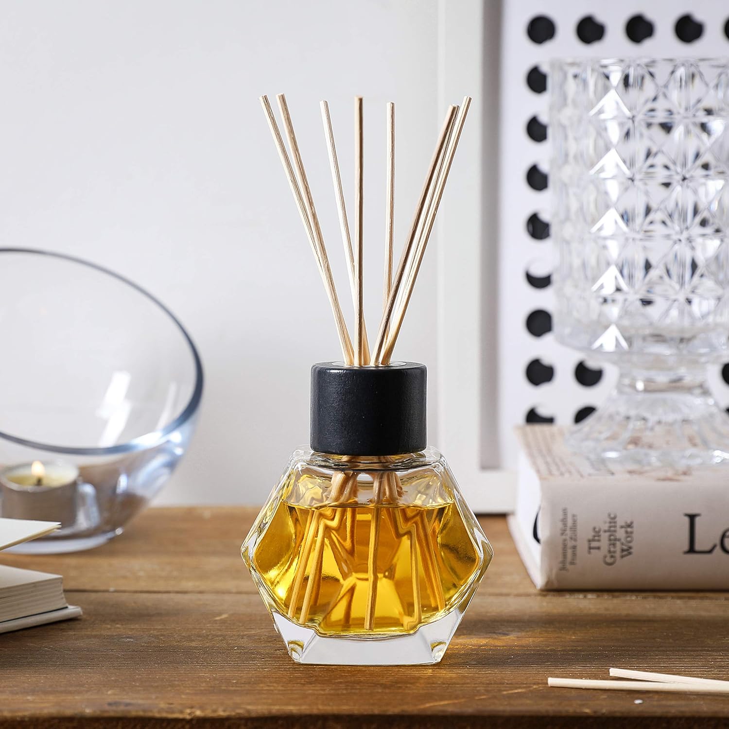 a glass bottle with a reed in it on a table