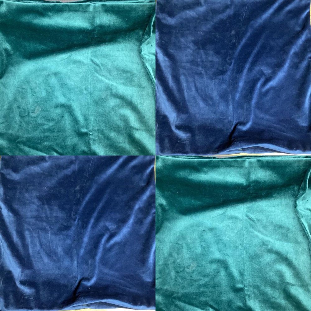 a green and blue blanket laying on top of a wooden floor